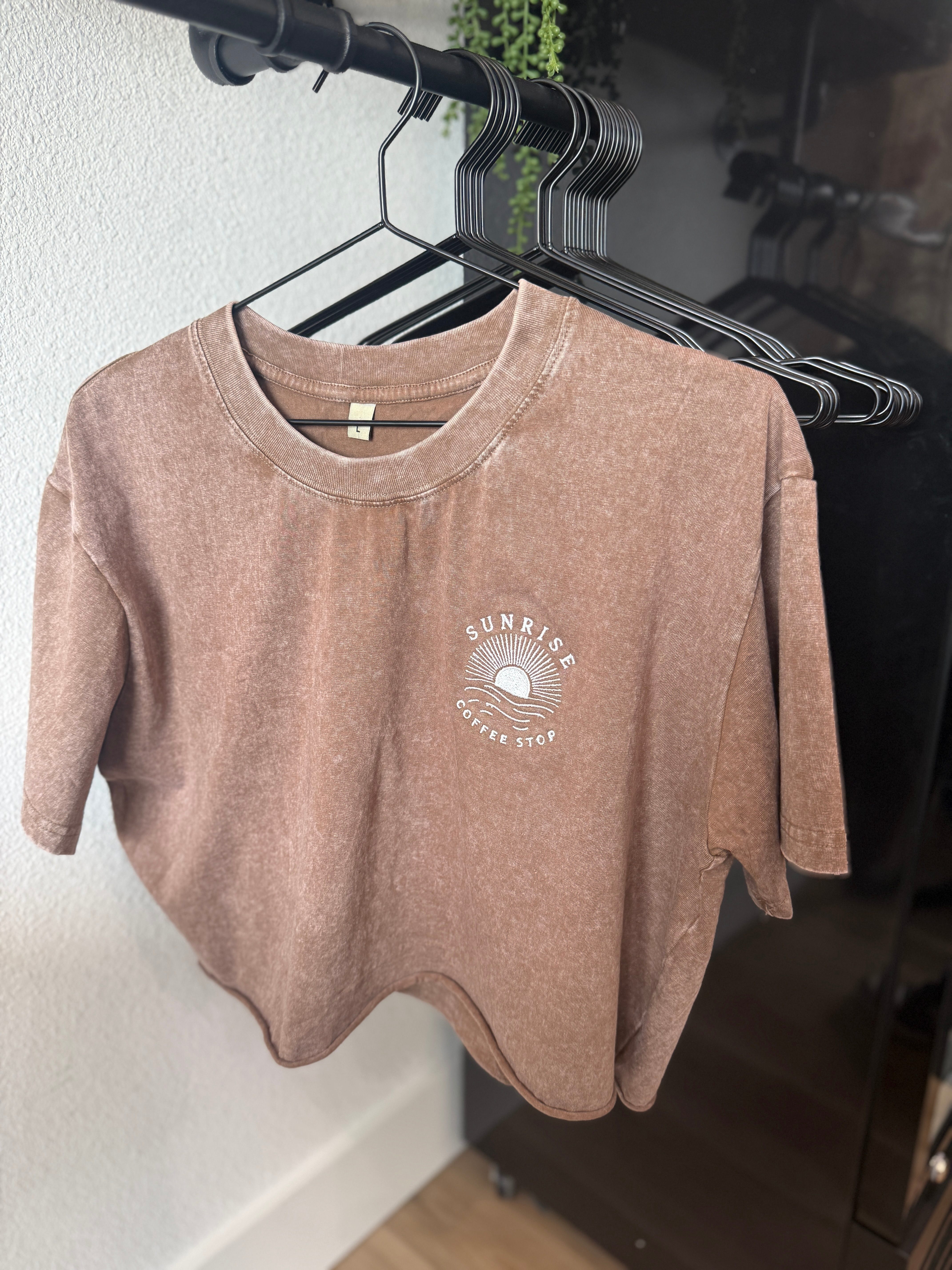 A folded cream Sunrise Coffee Stop t-shirt